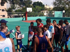 Andrew handing out Bibles to kids after intensive basketball practice.